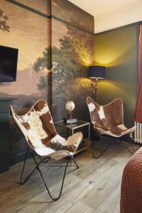 a living room with two chairs and a painting at 81 Promenade Studios in Cheltenham