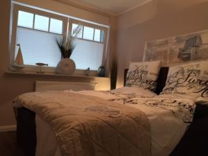 a bedroom with a large bed with a window at StrandVILLA Scharbeutz mit Dünenblick direkt am Strand in Scharbeutz