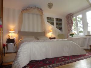 a bedroom with a white bed and two windows at Domaine du Bouloy in Druyes-les-Belles-Fontaines