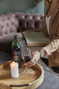 a woman holding a glass of wine and a candle at 81 Promenade Studios in Cheltenham