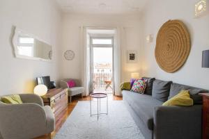 uma sala de estar com um sofá e uma mesa em Principe Real cool and artistic 3 bedrooms flat! em Lisboa