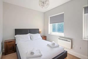 a bedroom with a bed with two towels on it at Glovers Lodge - Charming 3 Bed Retreat near City Centre in Derby