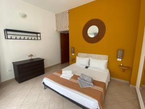 ein Schlafzimmer mit einem großen Bett und einer gelben Wand in der Unterkunft Leme Bedje - Two bedroom, Pool & Wifi in Santa Maria