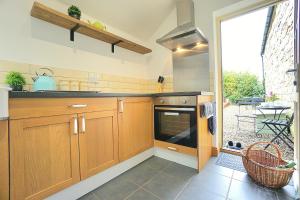 una cocina con armarios de madera y una gran ventana en MerryView near Rothbury, en Morpeth