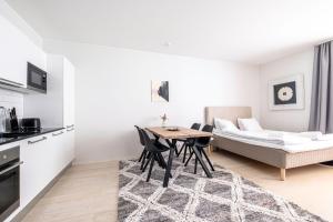 eine Küche und ein Wohnzimmer mit einem Tisch und einem Bett in der Unterkunft Nice studio apartment on a pedestrian street in Helsinki