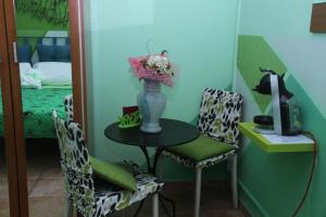 ein Tisch und Stühle mit einer Blumenvase drauf in der Unterkunft Oasi B&B in Benevento