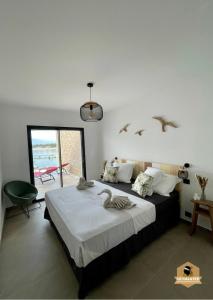 ein Schlafzimmer mit einem Bett mit Vögeln an der Wand in der Unterkunft Le Galatée Porticcio in Porticcio