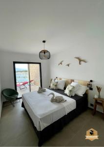 a bedroom with a bed with birds on the wall at Le Galatée Porticcio in Porticcio