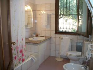 La salle de bains est pourvue d'un lavabo, de toilettes et d'une fenêtre. dans l'établissement Le Poiane B&B-Casa vacanze, à San Piero Patti