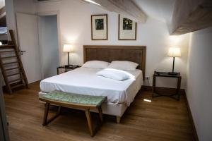 1 dormitorio con 1 cama blanca grande y 2 lámparas en RESIDENZA BALIOS en Vaglio di Basilicata