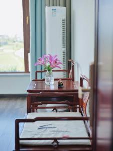 stół z wazonem kwiatów i dwoma krzesłami w obiekcie Dali Yard w mieście Dali