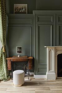 a room with green walls and a table and a chair at 81 Promenade Studios in Cheltenham