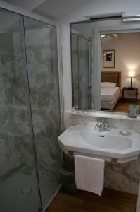 y baño con lavabo y ducha con espejo. en RESIDENZA BALIOS en Vaglio di Basilicata