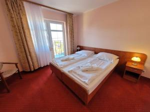 um quarto com uma cama grande e uma janela em Pensjonat SPA u Tomasza em Niechorze