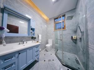 La salle de bains est pourvue d'un lavabo et d'une douche en verre. dans l'établissement Dali Yard, à Dali