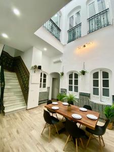 Triana Riverside Guesthouse في إشبيلية: غرفة طعام مع طاولة وكراسي خشبية