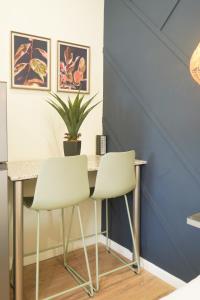 une table à manger avec deux chaises et un mur bleu dans l'établissement Hampton Collection - 2 Sleeper Studio Apartment with Pool, à Durban