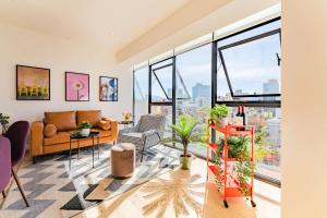 a living room with a couch and windows at NEW La Roma Penthouse 100m2 Terrace Pool and Gym in Mexico City +39 photos