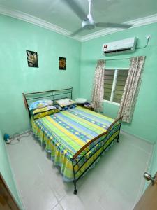 ein Schlafzimmer mit einem Bett in einem Zimmer in der Unterkunft Rumah Comel in Kampung Degong