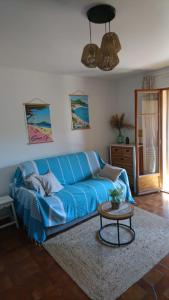 ein blaues Sofa im Wohnzimmer mit einem Tisch in der Unterkunft Studio week-end mer in Saint-Cyr-sur-Mer