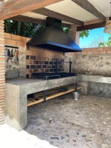 an outdoor kitchen with a stove with a hood at Cortijo Abril in Priego de Córdoba