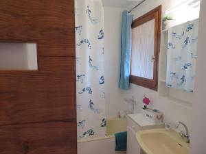 ein Badezimmer mit einem Duschvorhang mit blauen Dinosauriern darauf in der Unterkunft Studio week-end mer in Saint-Cyr-sur-Mer