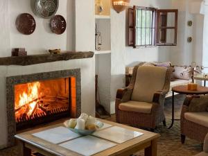 una sala de estar con chimenea y una mesa con un tazón. en Cortijo Abril en Priego de Córdoba