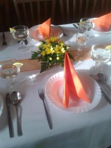 a table with a white table cloth and a plate with flowers at Pension U Štěpánků in Trpišovice