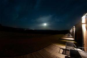 a deck at night with a full moon in the sky at Widokowe Stodoły Bieszczady in Lesko