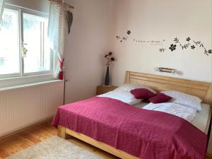 um quarto com uma cama com um cobertor roxo em Ferienhaus Zwickelreith em Göstling an der Ybbs