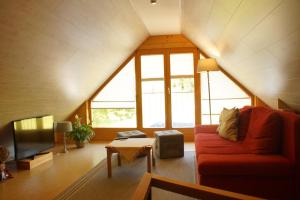 a living room with a red couch and a tv at Ferienhaus Zwickelreith in Göstling an der Ybbs