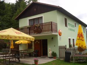 a building with an umbrella and tables and chairs at Pension U Štěpánků in Trpišovice