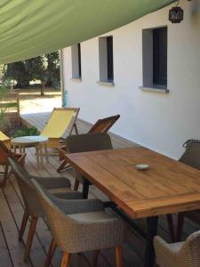 a wooden table and chairs on a patio at Maison cocooning proche plages in Soustons +11 photos