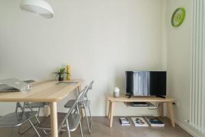 ミラノにあるPalermo Flexyrent Apartmentのデスク、テレビ、テーブルが備わる客室です。