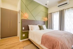 a bedroom with a large bed with green walls at Hampton Collection - Contemporary 3 Sleeper Apartment with Pool in Durban