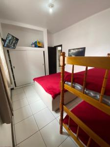 1 dormitorio con litera y manta roja en Apartamento Marisco, en Torres