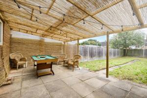 un patio con mesa de ping pong y sillas en LOW rate for a 4-Bedroom House in Coventry with Free Unlimited Wi-fi 2 Car Parking 53 QMC, en Coventry