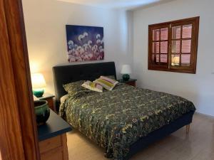 1 dormitorio con 1 cama, 2 lámparas y ventana en One bedroom bungalow Playa Bastian Costa Teguise, en Costa Teguise