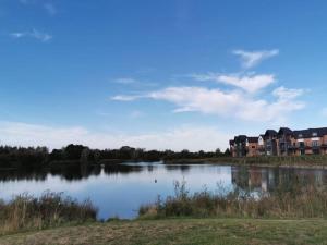 a view of a lake with houses in the background at 2 x King & 1 Single bedroom - Sleeps 5 - Kitchen - by Canal in Barton under Needwood