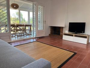 sala de estar con TV y chimenea en Casa a la Costa Brava, en Calonge