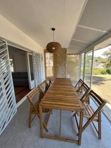 una mesa de comedor de madera y sillas en un porche en Casa a la Costa Brava, en Calonge