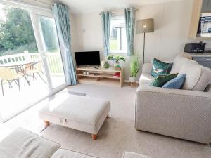 a living room with a couch and a tv at 62 Pinewood in Mablethorpe