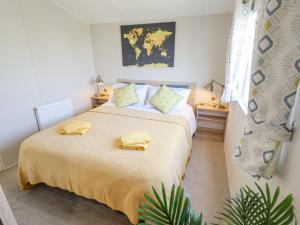 a bedroom with a bed with yellow towels on it at 62 Pinewood in Mablethorpe
