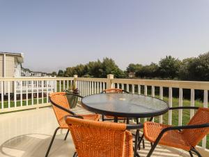 a patio with a table and chairs on a balcony at 62 Pinewood in Mablethorpe