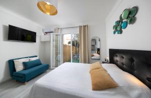 a bedroom with a bed and a blue chair at Bord de mer- Studio avec jardin in Roquebrune-Cap-Martin