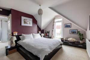 a bedroom with a large bed with a red wall at Stunning Sea View Home 2 Minutes Walk to the Beach in Bournemouth