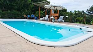 duży basen z niebieską wodą w obiekcie CASA MAR A VISTA w mieście Cumuruxatiba
