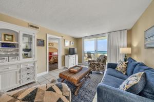 a living room with a blue couch and a table at Destin on the Gulf 403 - This is a beautiful beach front condo with a great view of the gulf in Destin