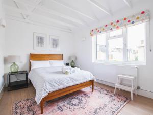 a white bedroom with a bed with a rug at Pass the Keys Peckham House with garden London in London