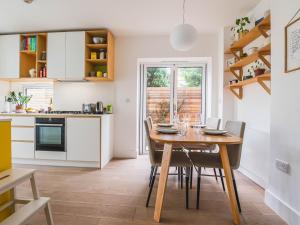 a kitchen and dining room with a wooden table and chairs at Pass the Keys Peckham House with garden London in London